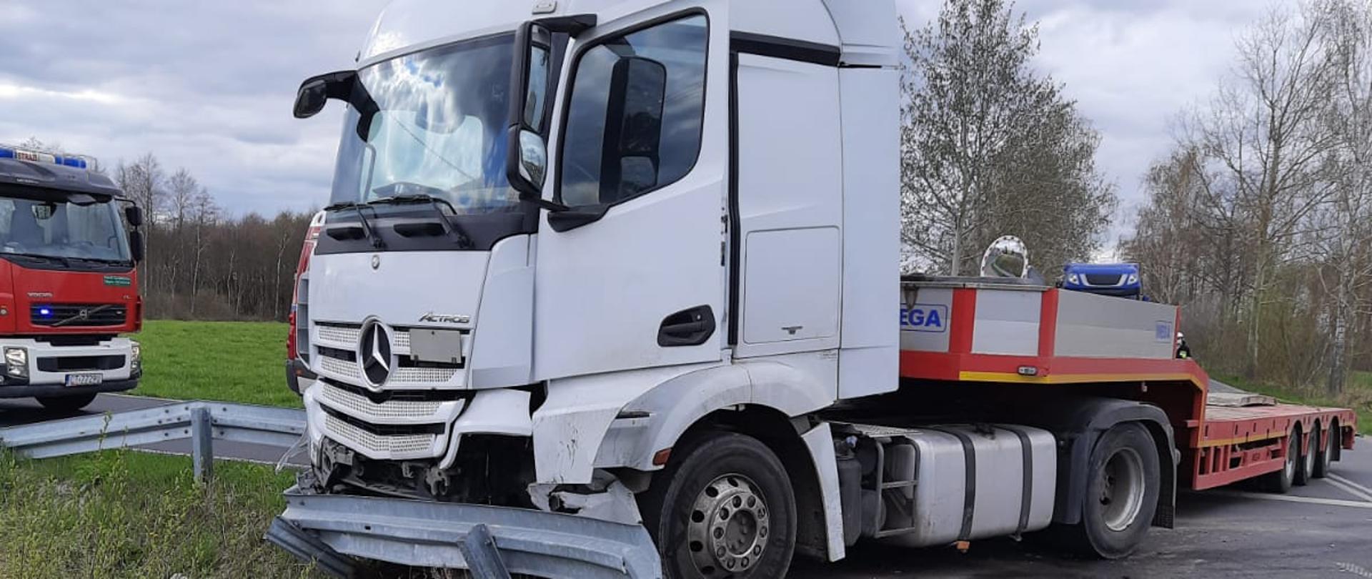 na zdjęciu samochód ciężarowy autolaweta biorący udział w wypadku z samochodem osobowym. Z lewej strony zdjęcia samochód ratowniczo-gaśniczy z Komendy Powiatowej Państwowej Straży Pożarnej w Świeciu