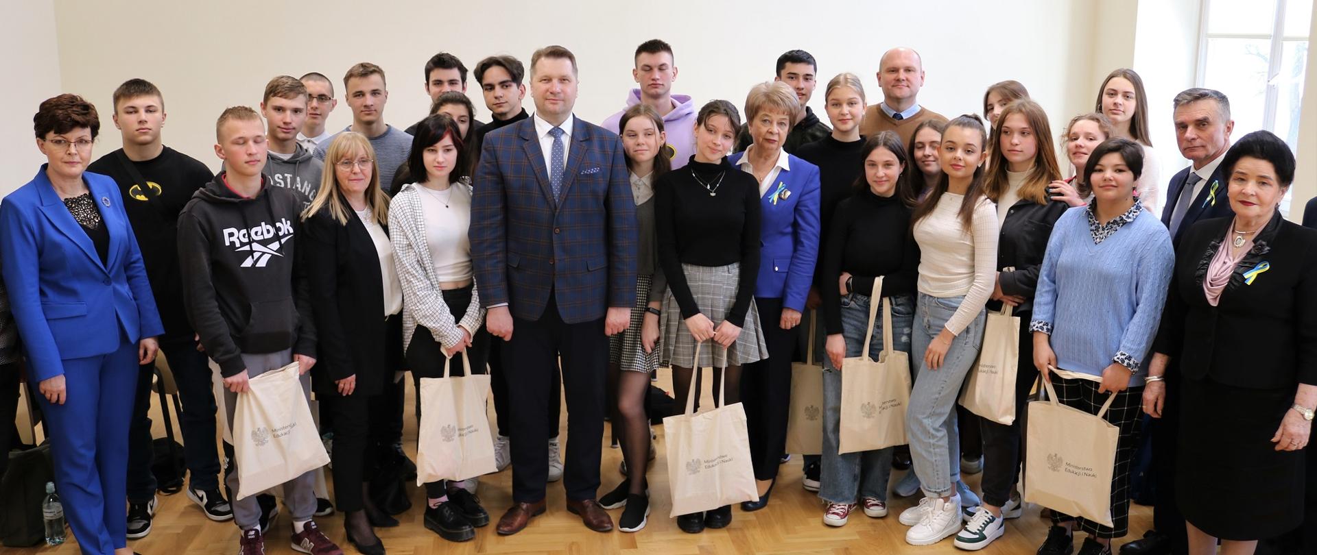 Spotkanie Ministra Edukacji i Nauki z polskimi i ukraińskimi uczniami Zespołu Szkół Ekonomicznych w Lublinie. Zdjęcie grupowe, minister stoi w otoczeniu uczniów.