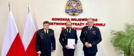 Na zdjęciu na tle flagi Polski oraz logo PSP - od lewej bryg. mgr Andrzej Wójtowicz Komendant Powiatowy PSP w Szczecinku, p.o. Zastępcy Komendanta Powiatowego PSP w Szczecinku st. kpt. Michał Popowicz, po prawej Zachodniopomorski Komendant Wojewódzki PSP w Szczecinie st. bryg. mgr inż. Jarosław Tomczyk. 