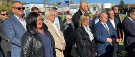 Grupa osób stoi na placu