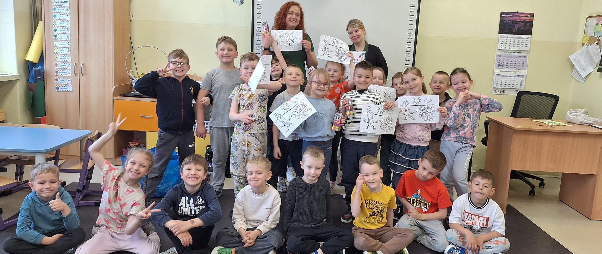 dzieci z Inspektorkami WIJHARS z rękach trzymają kolorowanki 