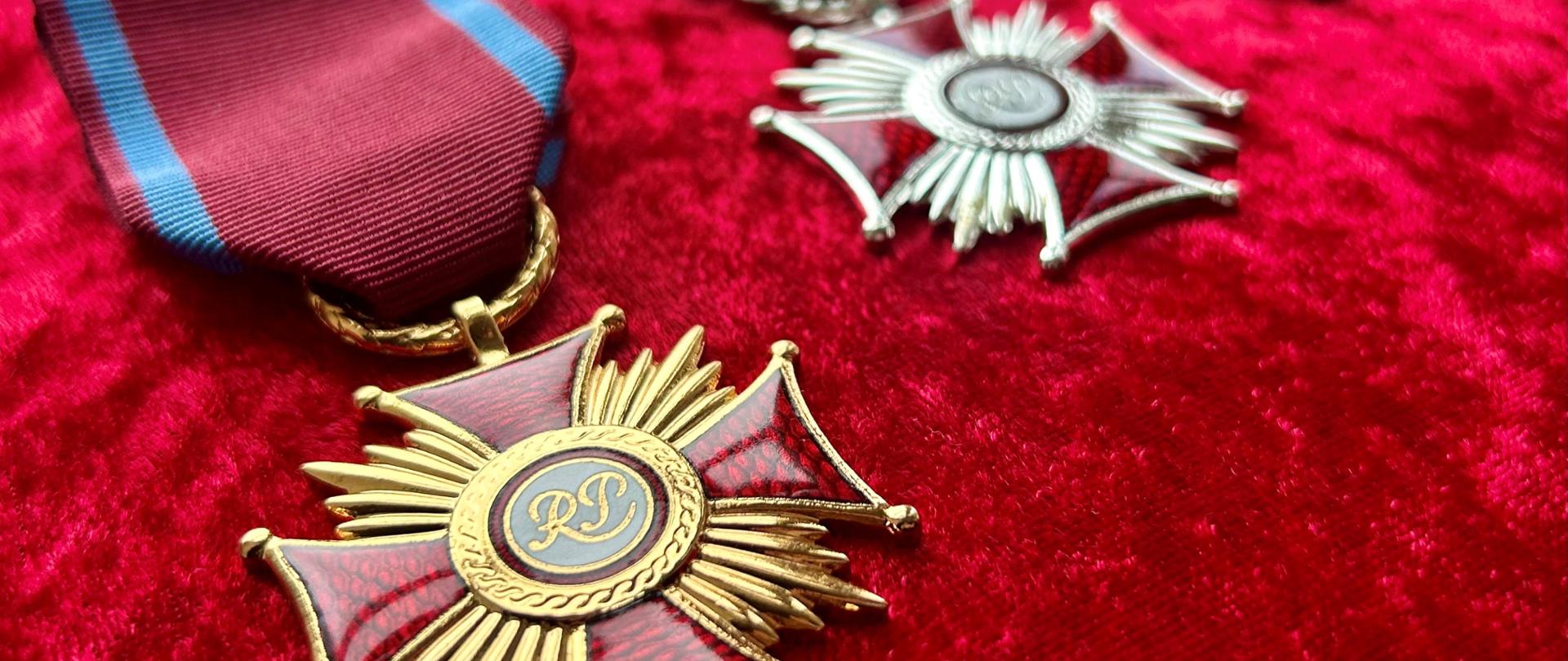 medale leżące na czerwonej poduszce