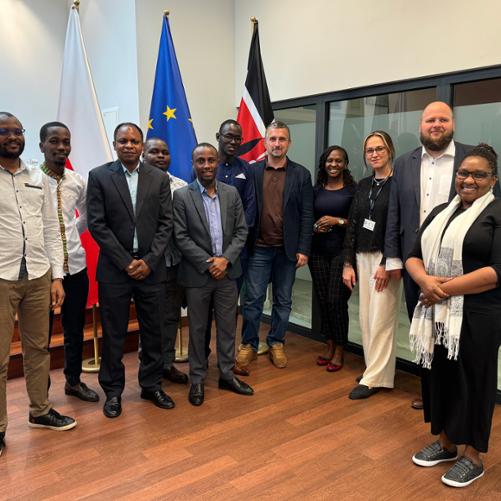 Grupa osób pozuje do zdjęcia w sali konferencyjnej