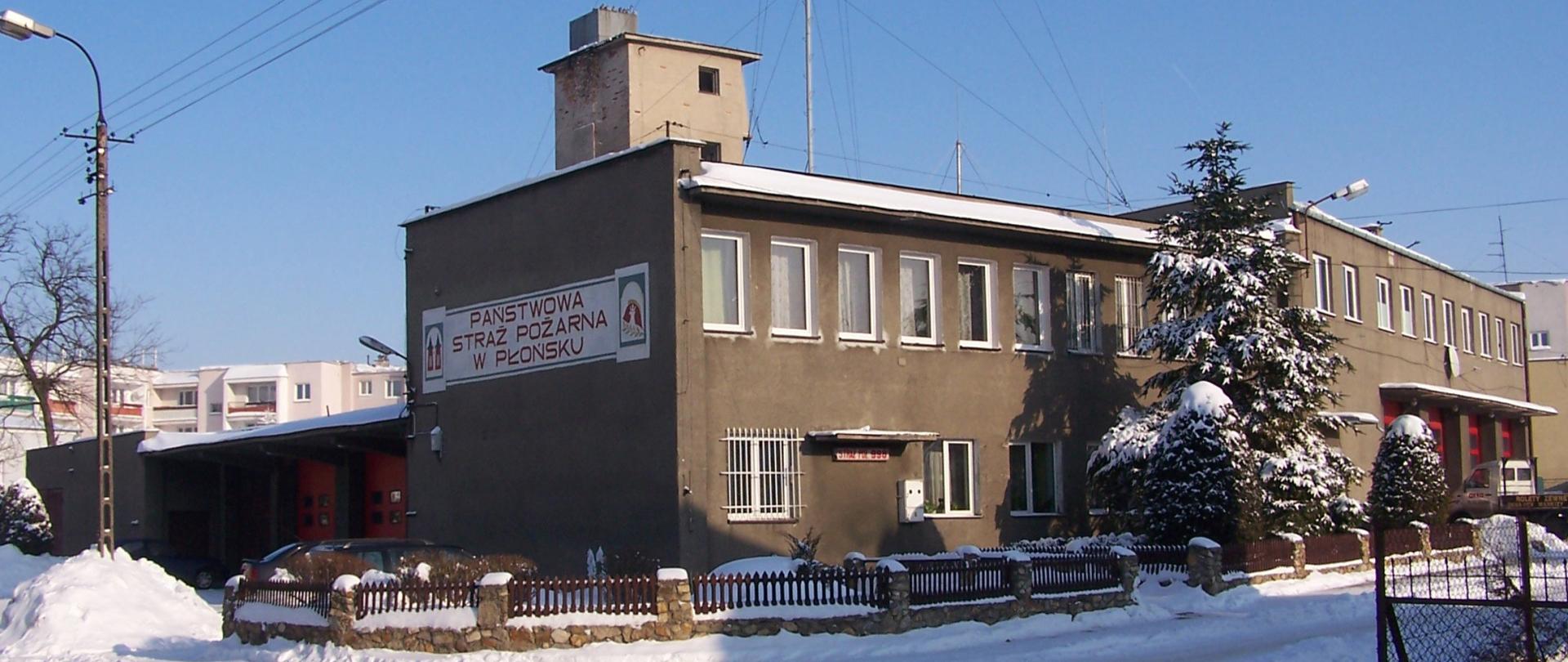 Budynek szary, dwukondygnacyjny, zima, Płońsk ul. Rutkowskiego 