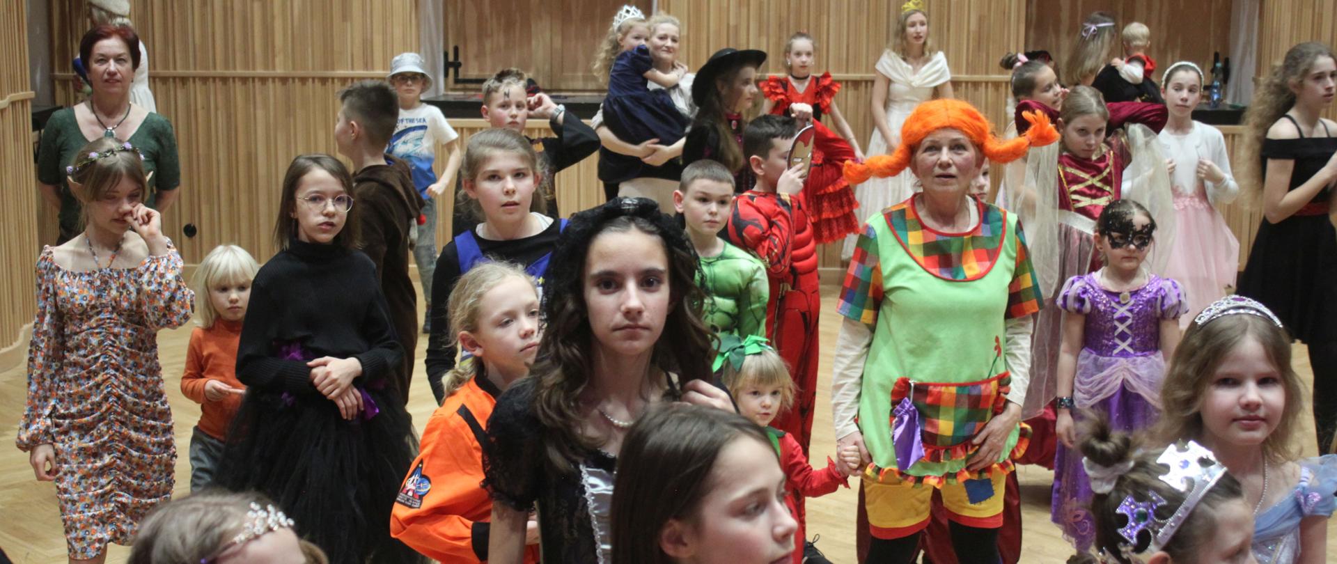 Zdjęcie. Uczniowie oraz nauczyciele PSM Nysa w trakcie zabawy karnawałowej w Sali Koncertowej.