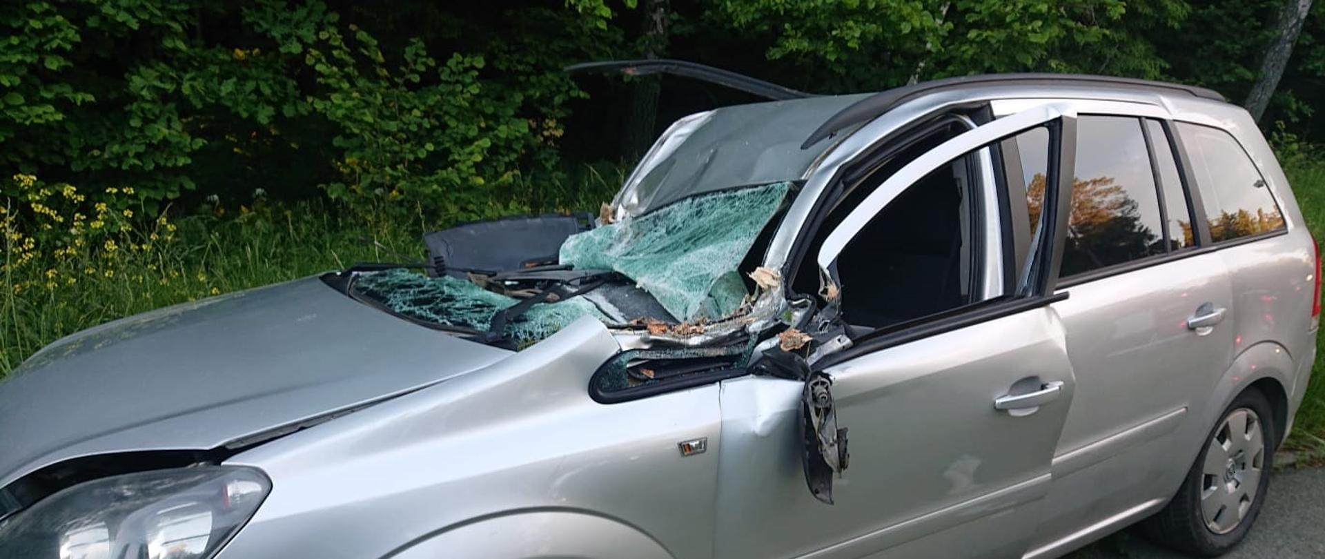 Zdjęcie obrazuje uszkodzony samochód osobowy o jasnym kolorze
