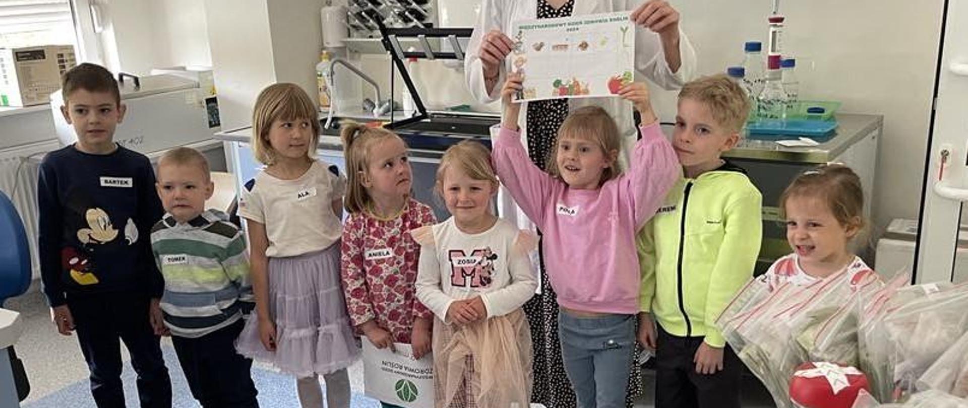 Dzieciaki z dumą prezentują uzbierane odznaki