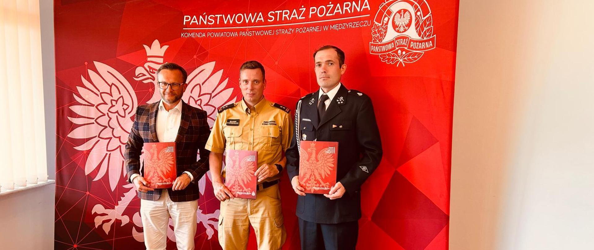 Zdjęcie przedstawia Komendanta Powiatowego PSP w Międzyrzeczu bryg. Marek Koperwasa, Wójta Gminy Pszczew Pana Krystiana Grabowskiego oraz Prezesa OSP Silna Dariusza Kuskę podczas spotkania w KP PSP Międzyrzecz, w trakcie którego zostało podpisane trójstronne porozumienie