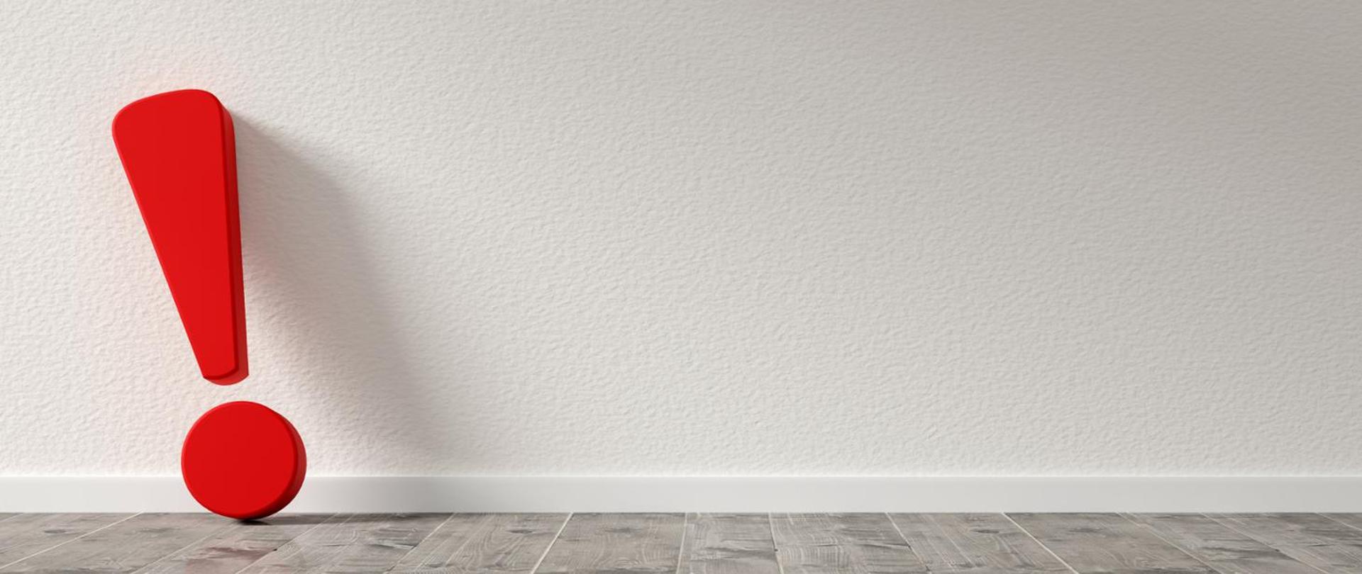 Czerwony wykrzyknik "stojący" pod ścianą