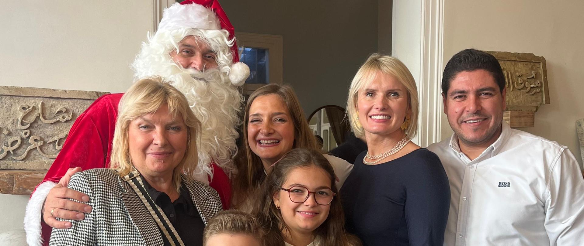 Grupa Polaków pozująca do zdjęcia w tym Św. Mikołaj