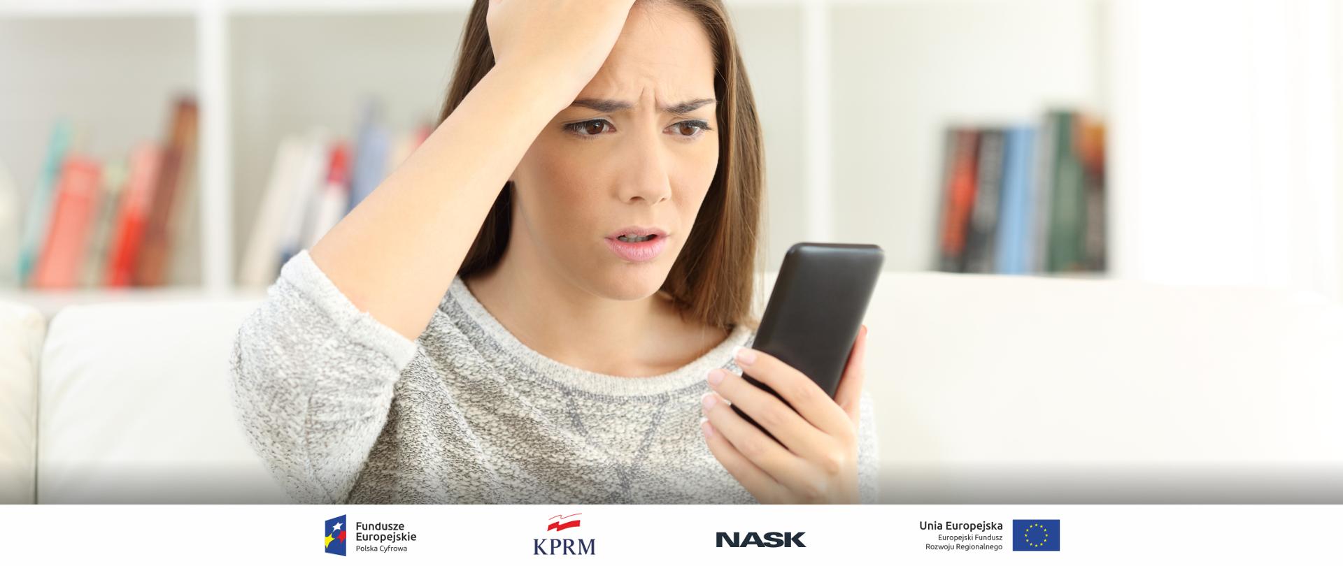 Młoda zdzwiona i zasmucona kobieta spogląda na swój telefon komórkowy. Prawdopodobnie otrzymała jakąś niechcianą wiadomość. 