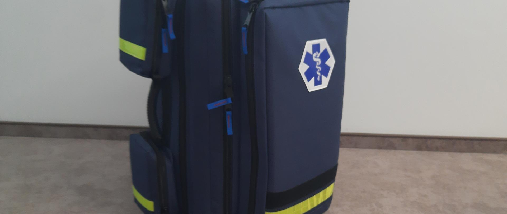 Plecak medyczny koloru granatowego z logo ratownictwa medycznego na środku torby.