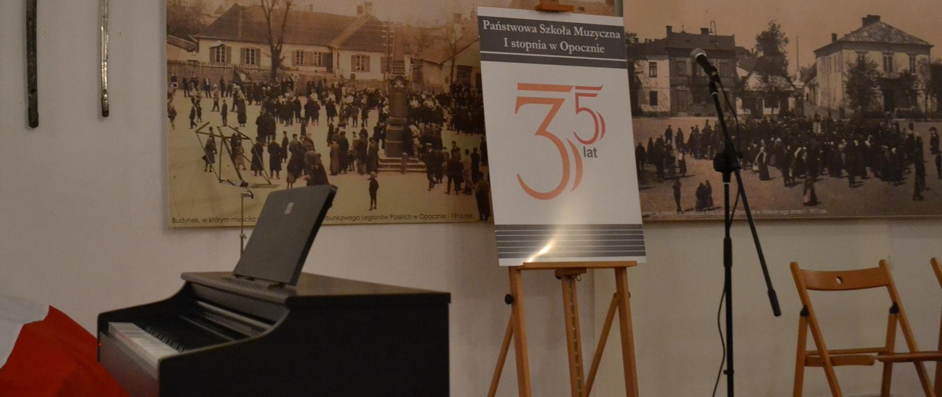 Zdjęcie przedstawiające umieszczony na stojaku plakat z okazji 35-lecia Państwowej Szkoły Muzycznej I stopnia w Opocznie.