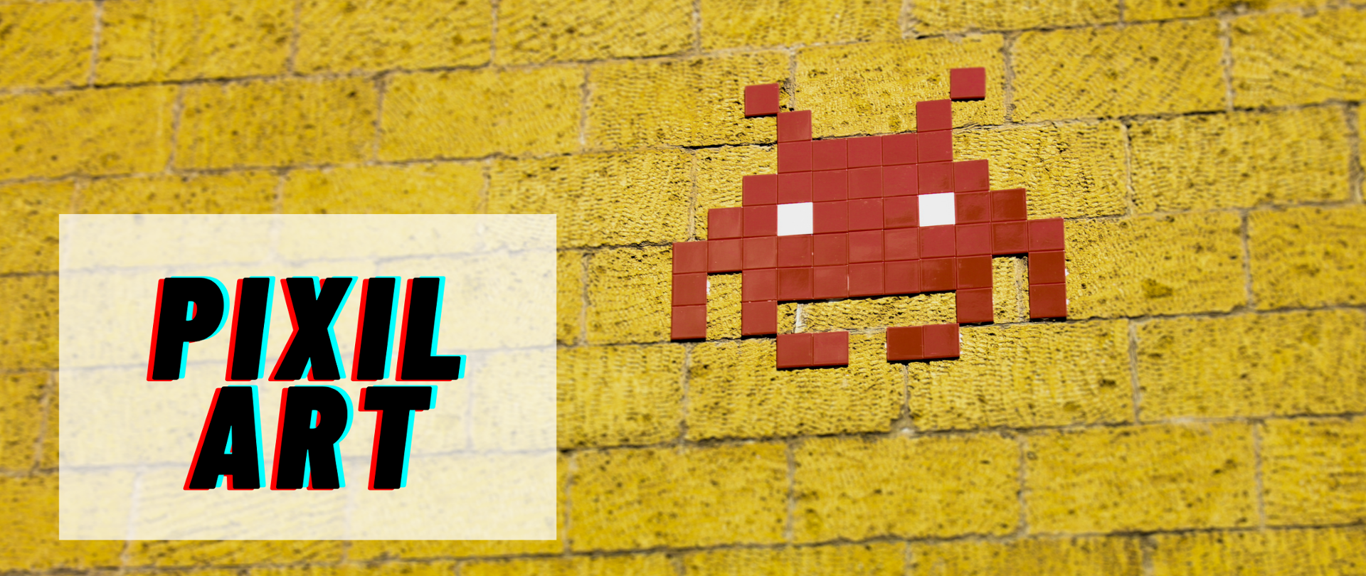 Grafika jest żółta, ułożona z cegieł. Na niej ułożony jest z drobnych kwadratów robot. W lewym dolnym rogu na zabielonym tle widać napis: PIXIL ART.