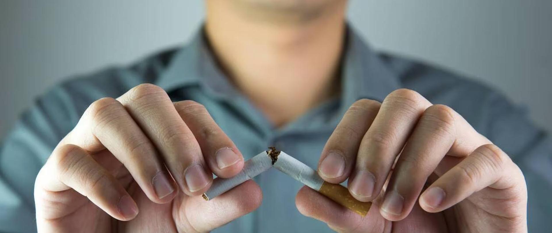 mężczyzna łamiący w dłoniach papierosa