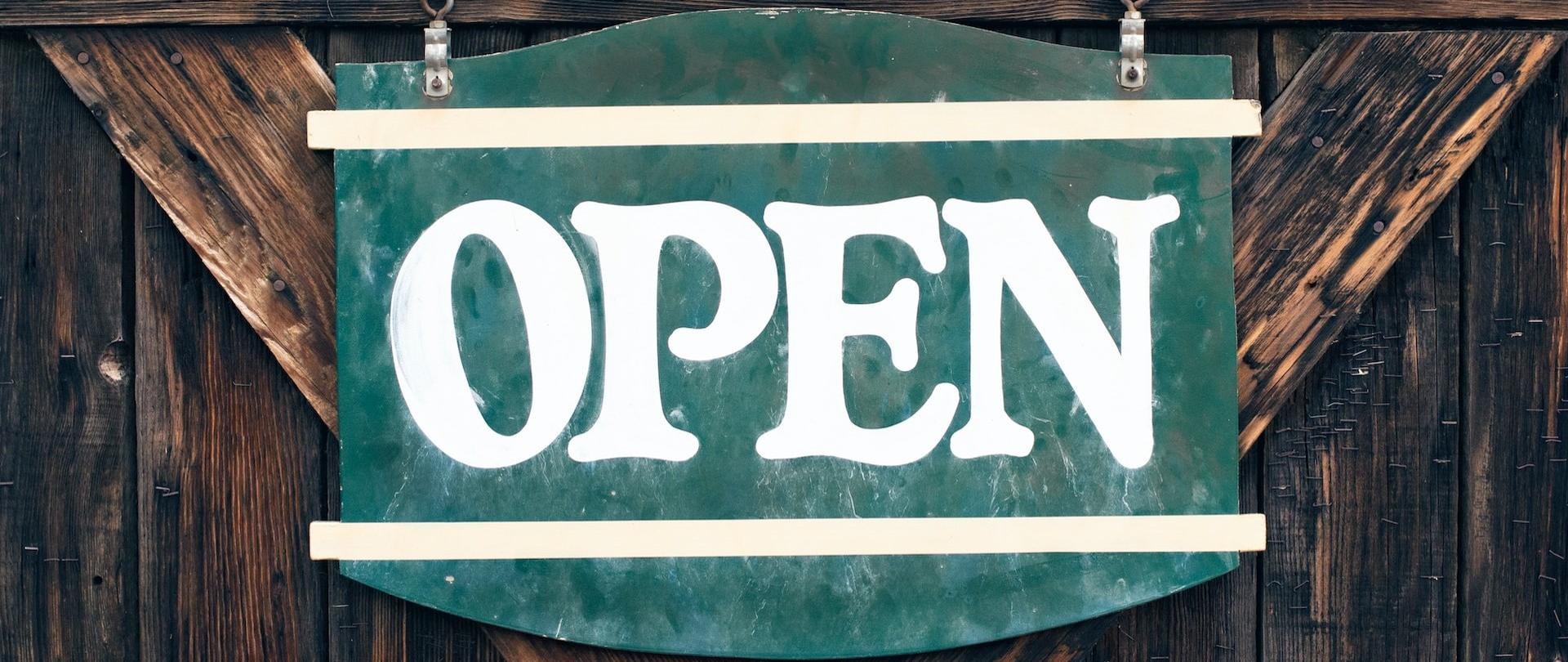 Zielony szyld z białym napisem open