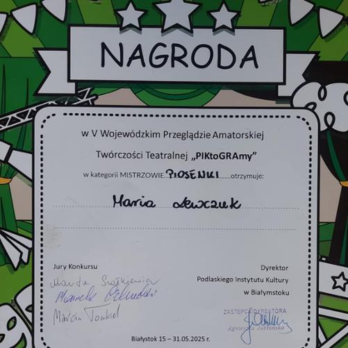 Na plakacie w jego górnej środkowej części umieszczony jest napis Nagroda. Pod napisem widnieje zdanie: w Wojewódzkim Przeglądzie Amatorskiej Twórczość Teatralnej "PIKtoGRAmy" w kategorii Mistrzowie Piosenki otrzymuje Maria Lewczuk. W lewym dolnym roku umieszczone są podpisy Jury. W prawym dolnym roku umieszczona jest pieczątka i podpis Dyrektora Podlaskiego Instytutu Kultury w Białymstoku. Tło plakatu utrzymane jest w biało- zielonych barwach.
