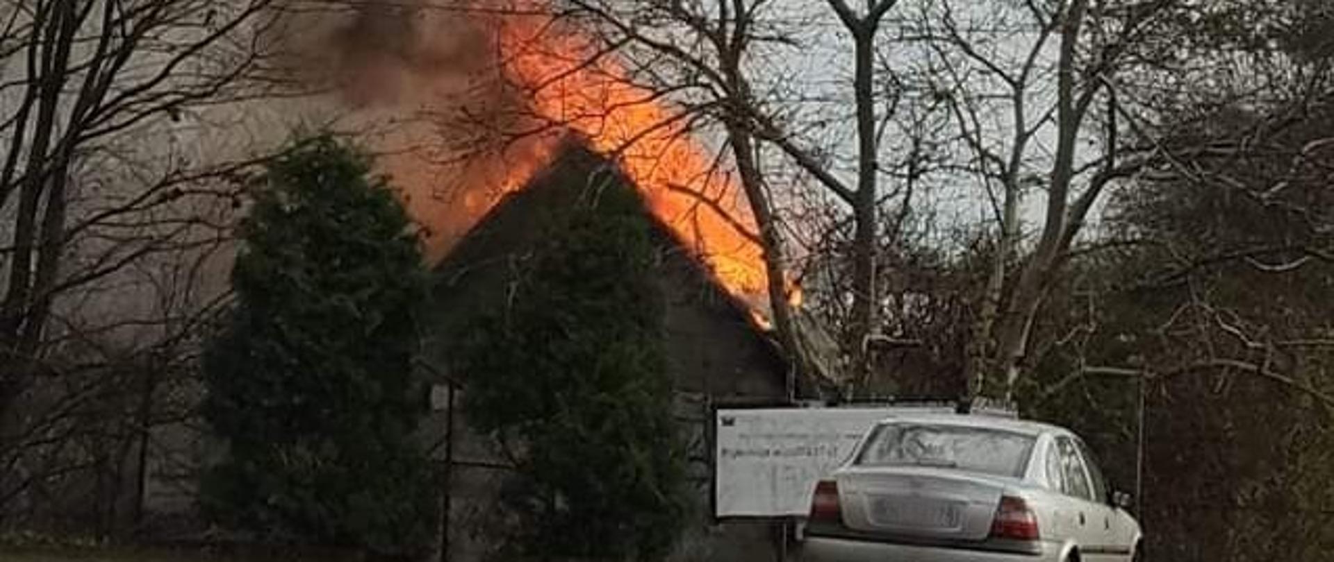 Na zdjęciu widać zarys domu całego w płomieniach.