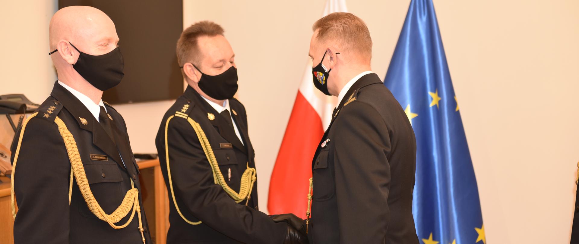 Zdjęcie przedstawia funkcjonariuszy PSP w umundurowaniu wyjściowym podczas uroczystości zdania i powierzenia obowiązków Komendanta Powiatowego PSP w Zduńskiej Woli