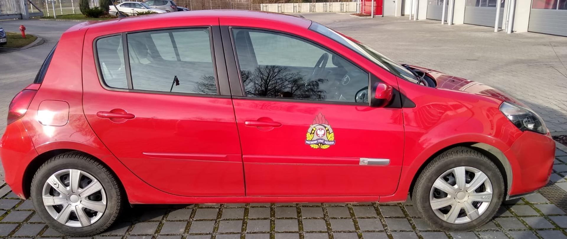 Na zdjęciu samochód renault clio - lekki samochód operacyjny czerwony na tle komendy 