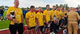 Zdjęcie przedstawia wręczanie nagród i medali za uzyskanie pierwszego miejsca w klasyfikacji generalnej zawodów