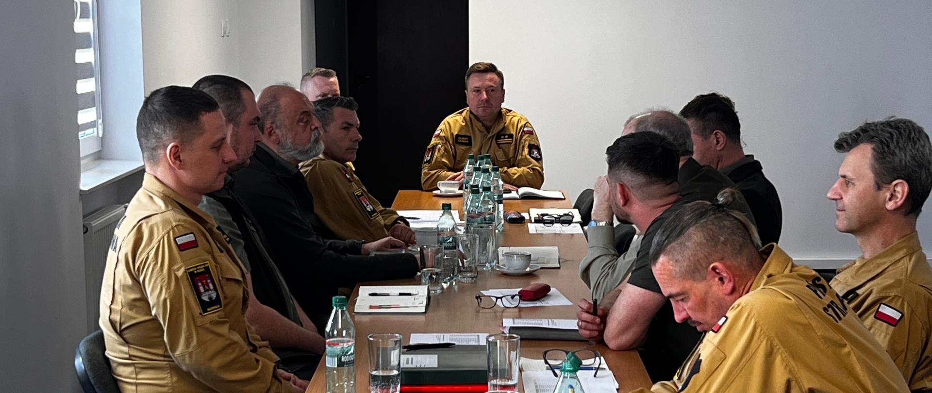 Na zdjęciu widzimy siedzących przy stole Sali konferencyjnej: funkcjonariuszy Komendy Miejskiej Państwowej Straży Pożarnej w Płocku, przedstawicieli Nadleśnictw: Płock, Łąck, Gostynin oraz Starostwa Powiatowego w Płocku i Urzędu Miasta Płocka podczas narady.