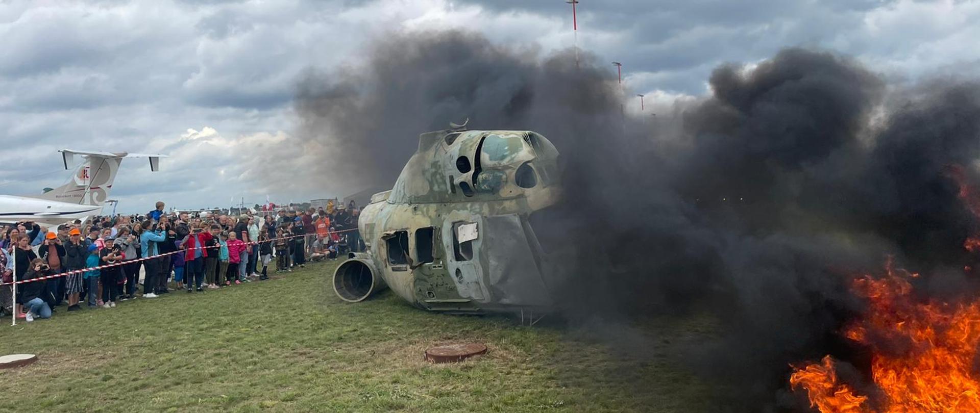 Wrak śmigłowca zadymiony, widać ogień obok śmiglowca