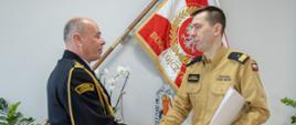Na zdjęciu widoczni na tle sztandaru komendant główny PSP nadbryg. dr inż. Mariusz Feltynowski wręczający akt powołania na stanowisko zastępcy małopolskiego komendanta wojewódzkiego PSP st. bryg. mgr inż. Piotrowi Gadowskiemu.