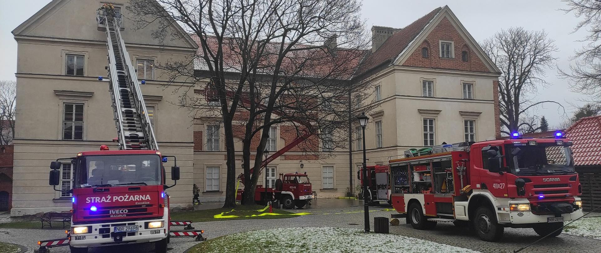 Przy budynku muzeum ustawione samochody czerwone strażackie.
