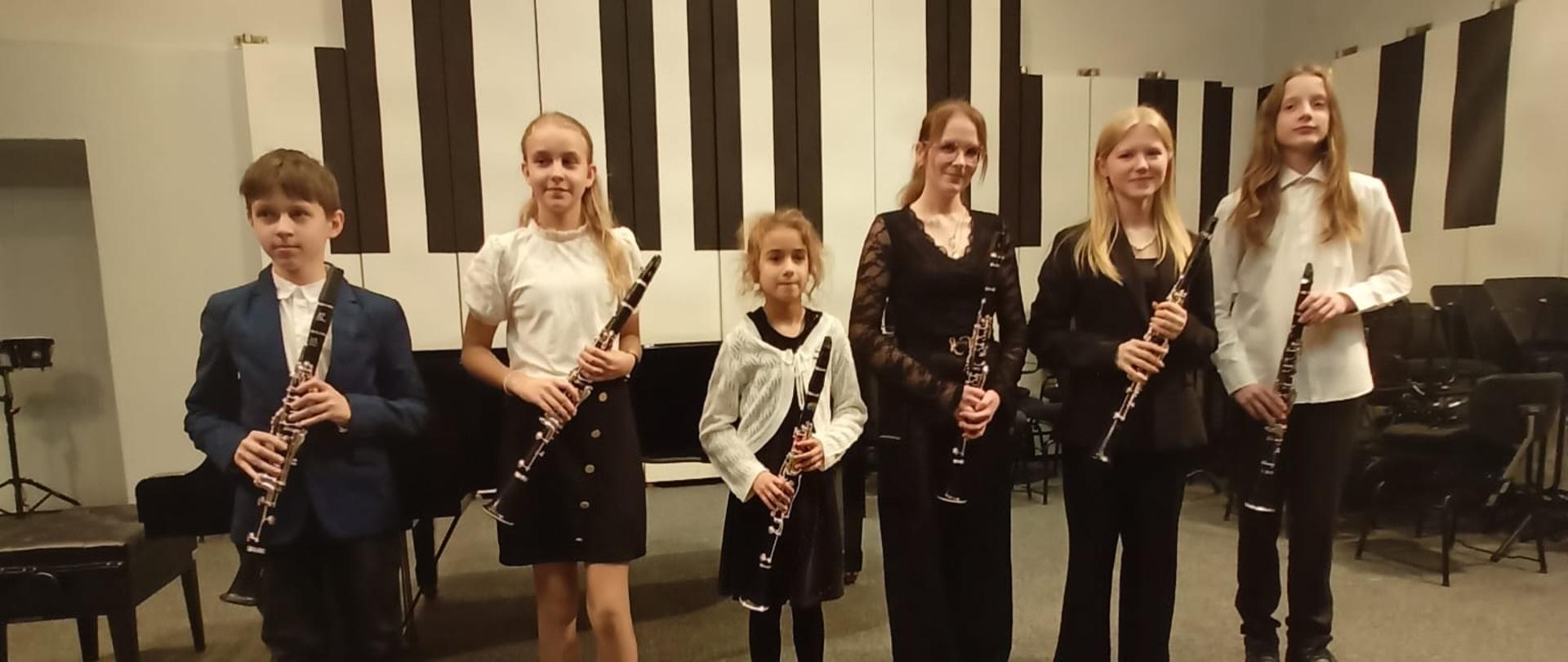 Wszyscy wykonawcy stoją na scenie z klarnetami.