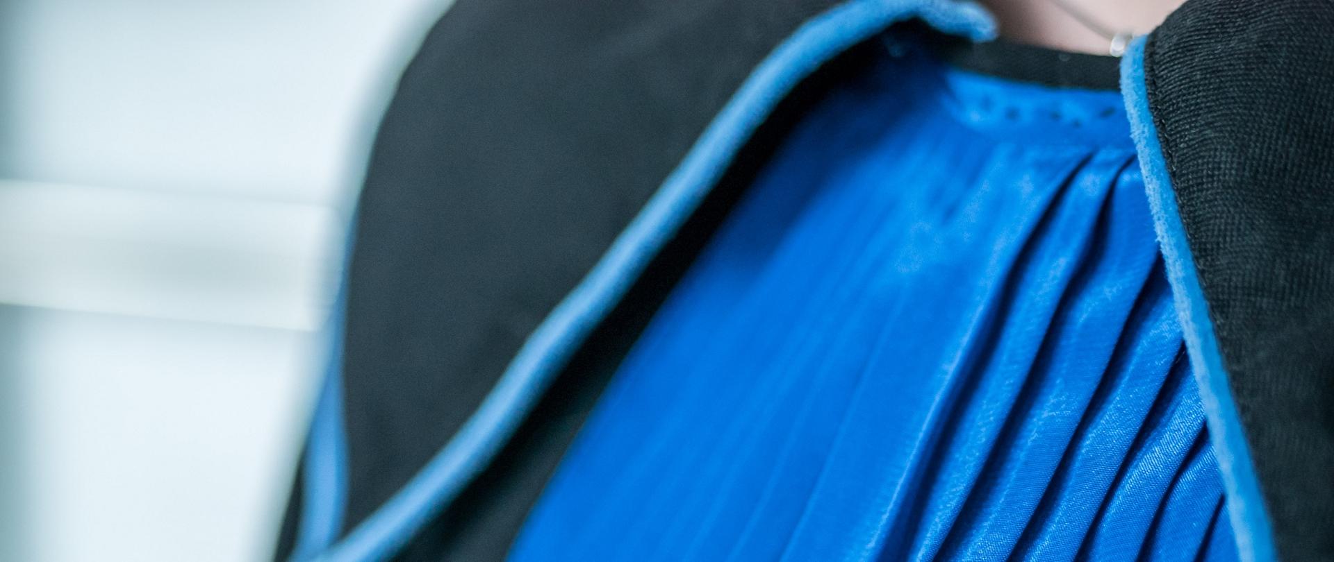 Widok górnej części sędziowskiej togi w kolorze czarno-niebieskim