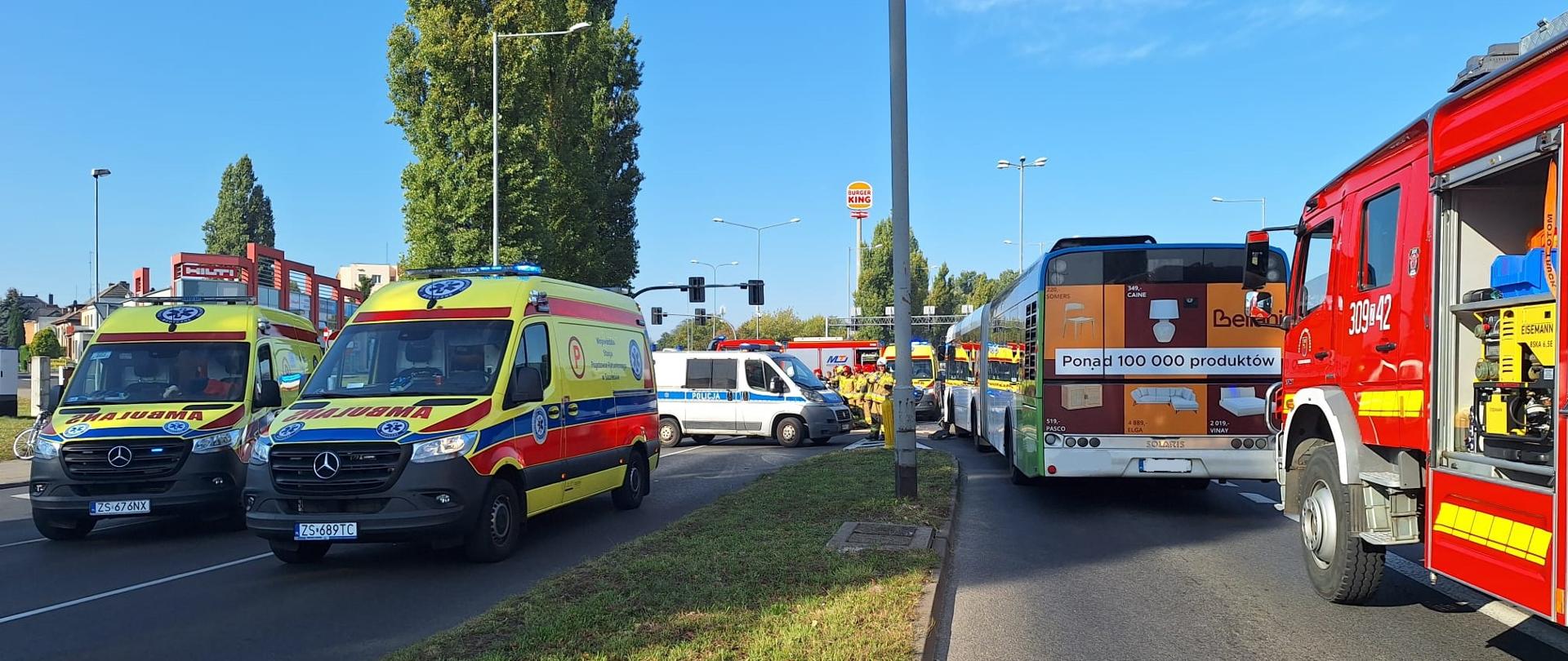 Widoczne autobus komunikacji miejskiej, dwie karetki pogotowia ratunkowego, samochód straży pożarnej i radiowóz. 