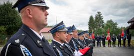 Na zdjęciu widoczni strażacy OSP w ubraniach galowych koloru granatowego stojący w pododdziale podczas uroczystego apelu z okazji przekazania samochodu ratowniczo-gaśniczego dla OSP Smerekowiec