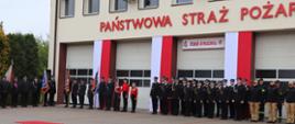 Pododdziały strażaków PSP oraz strażaków OSP wraz z MDP, pocztami sztandarowymi ustawione wzdłuż bram budynku głównego KP PSP w Środzie Wielkopolskiej podczas uroczystych obchodów Dnia Strażaka