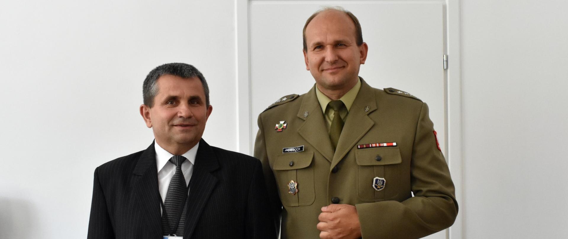 Dyrektor WIChiR dr inż. Bogusław Kot, wraz z zastępcą - pułkownikiem Grzegorzem Cielochem stoją uśmiechnięci ramię w ramię po oficjalnym przekazaniu obowiązków.