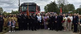 Zaproszeni goście na tle samochodów ratowniczo - gaśniczych. 