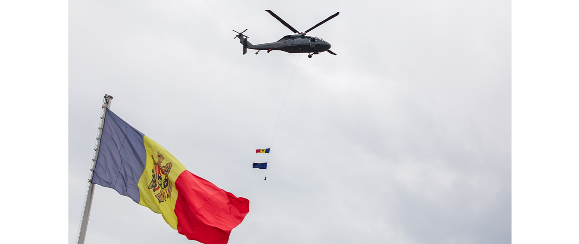 Policyjny Black Hawk w powietrzu; na linie flagi UE i Mołdawii 