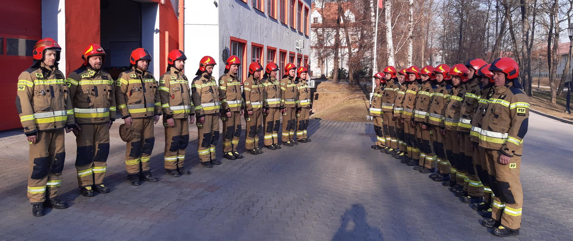 Strażacy w umundurowaniu bojowym stoją na zmianie służby. Minuta ciszy w hołdzie strażakom poległym na Ukrainie