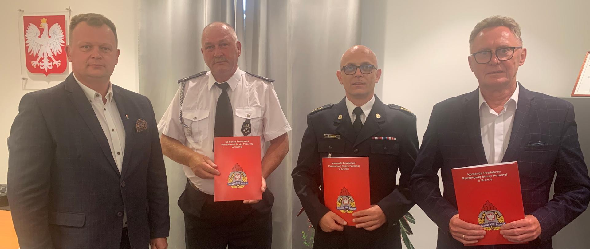 Na zdjęciu Komendant Powiatowy PSP w Śremie, Kurmistrz i zastępca Śremu oraz prezes OSP Pysząca trzymający podpisane porozumienia w tle Godło Polski