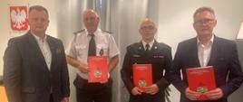 Na zdjęciu Komendant Powiatowy PSP w Śremie, Kurmistrz i zastępca Śremu oraz prezes OSP Pysząca trzymający podpisane porozumienia w tle Godło Polski