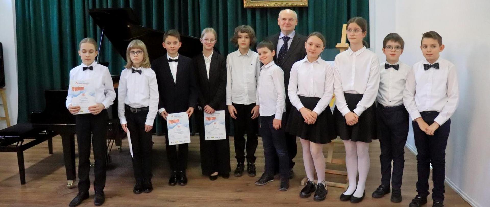 Na zdjęciu przedstawione są dzieci, które zwyciężyły w VI Konkursu Zespołów Fortepianowych „Na cztery ręce i więcej”