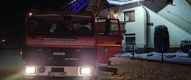 Na zdjęciu znajduje się samochód drabina pożarnicza, w tle widać budynek mieszkalny