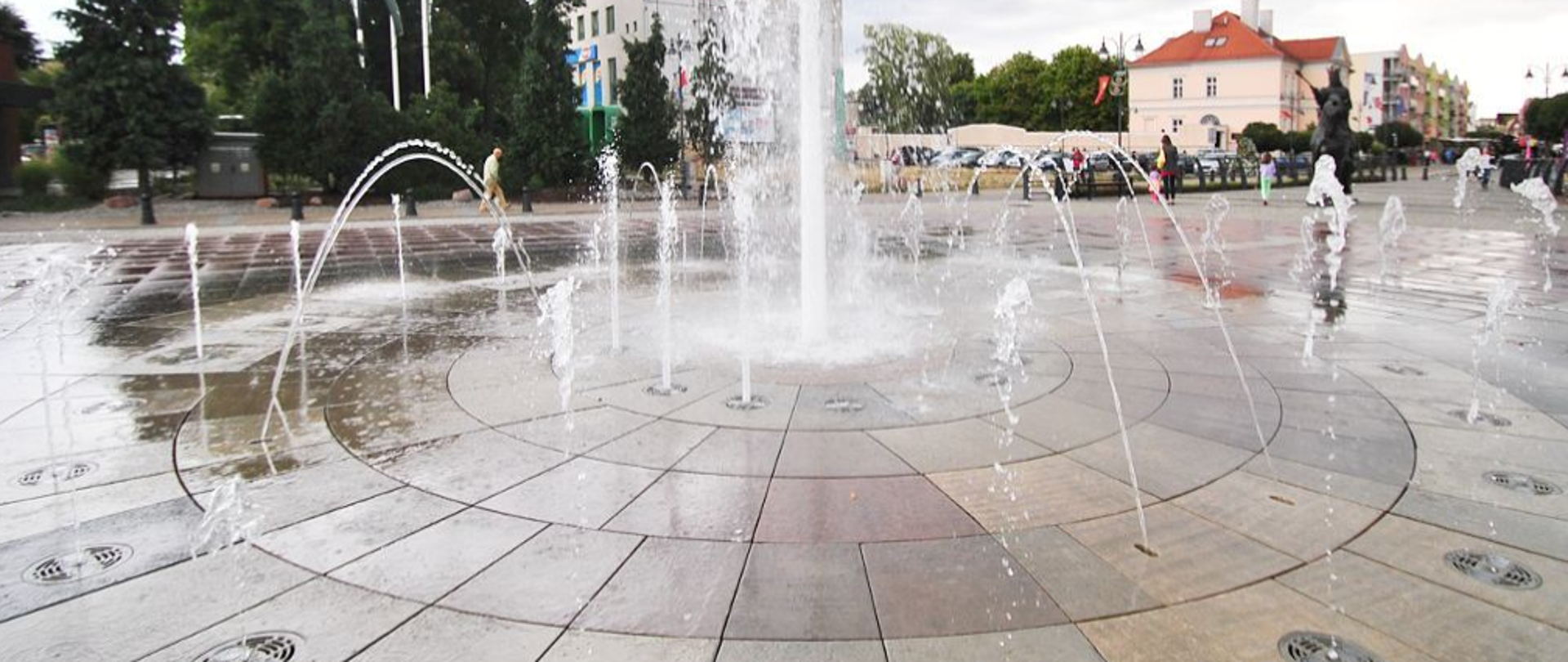 woda wypływająca do góry z otworów, które znajdują się w płycie fontanny.