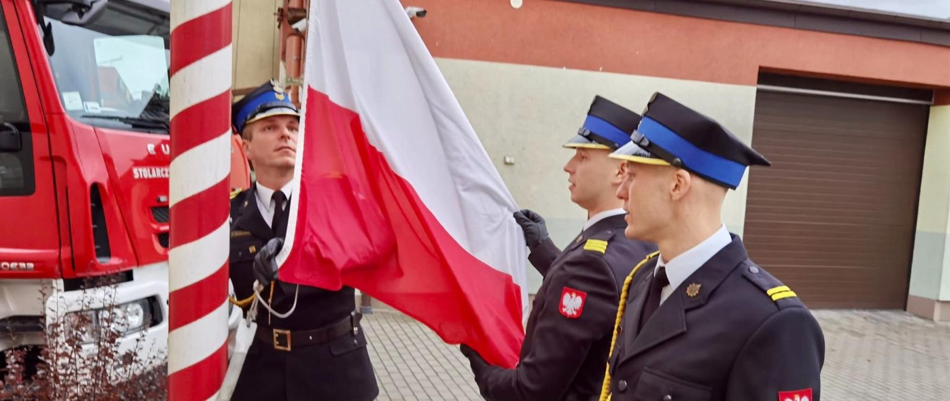Zdjęcie przedstawia moment wciągnięcia flagi państwowej na maszt