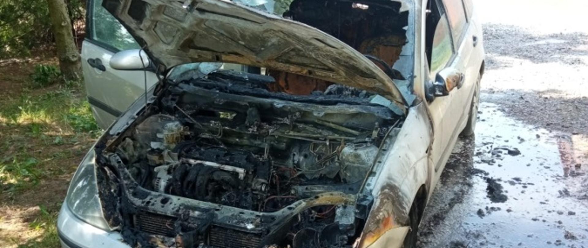 Na zdjęciu widoczny samochód osobowy typu combi w kolorze srebrnym, ze spaloną komorą silnika.