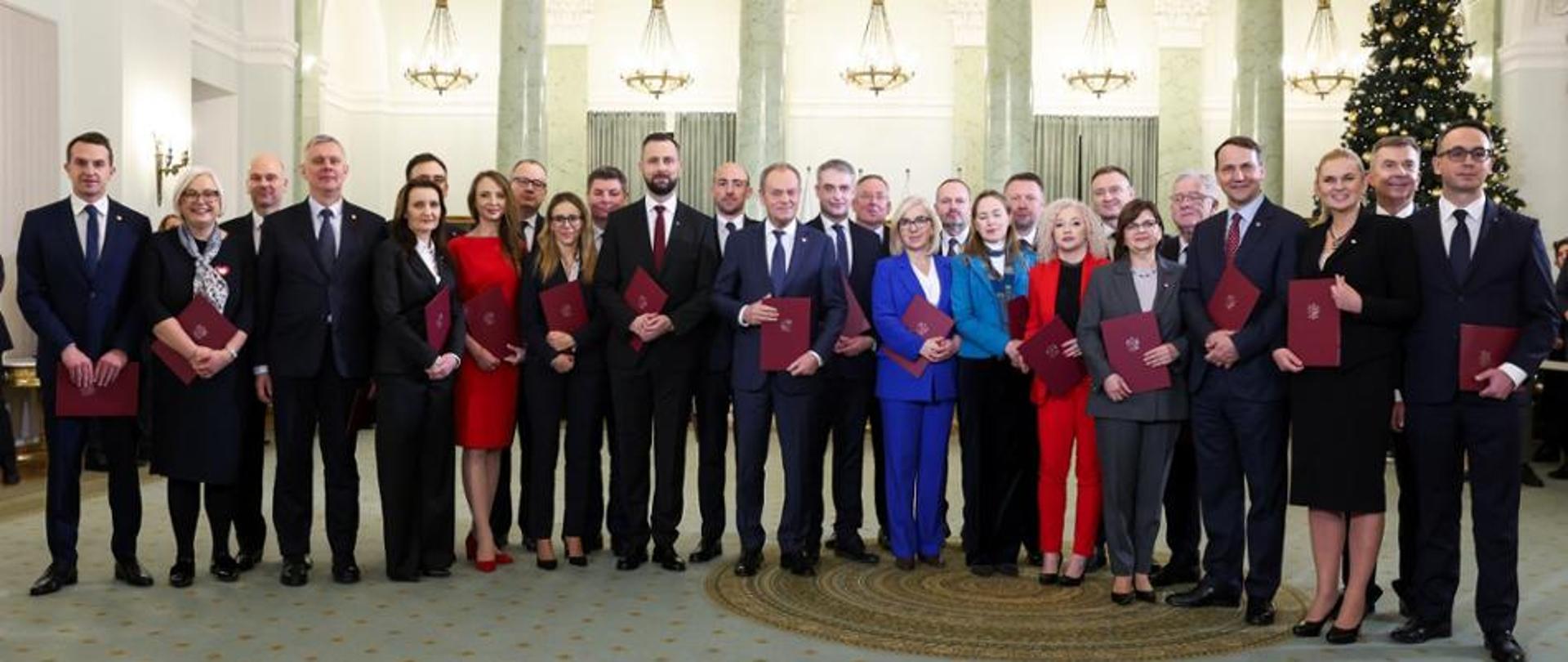 a group photo of men and women appointed as cabinet ministers standing with Prime Minister in the center. Minister of Sport and Tourism - Slawomir Nitras - is the seventh on the right