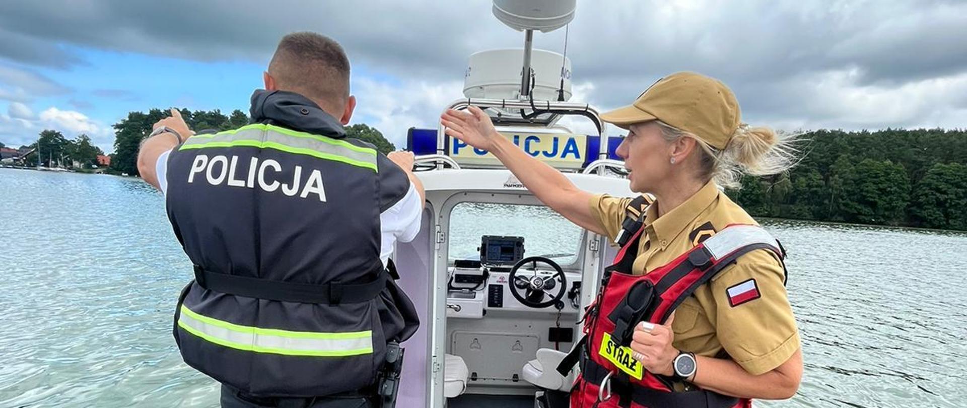 Funkcjonariusz PSP i Policji w kokpicie motorówki.