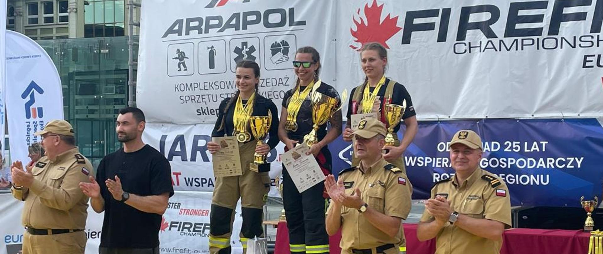 Na zdjęciu st.str. Ewa dobrzyńska na podium wraz z towarzyszącymi jej strażakami