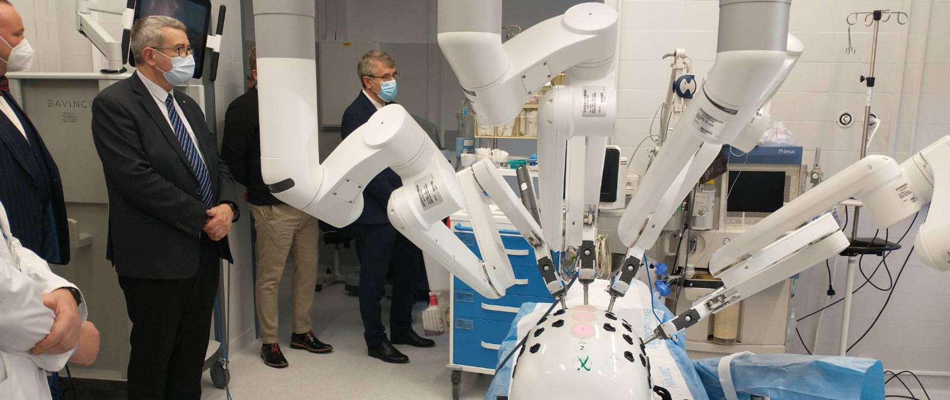 Otwarcie Pracowni Robotycznej na WUM z udziałem wiceministra Wojciecha Murdzka, wiceminister Wojciech Murdzek wraz z pracownikami WUM ogląda nowoczesny sprzęt do operacji chirurgicznych.