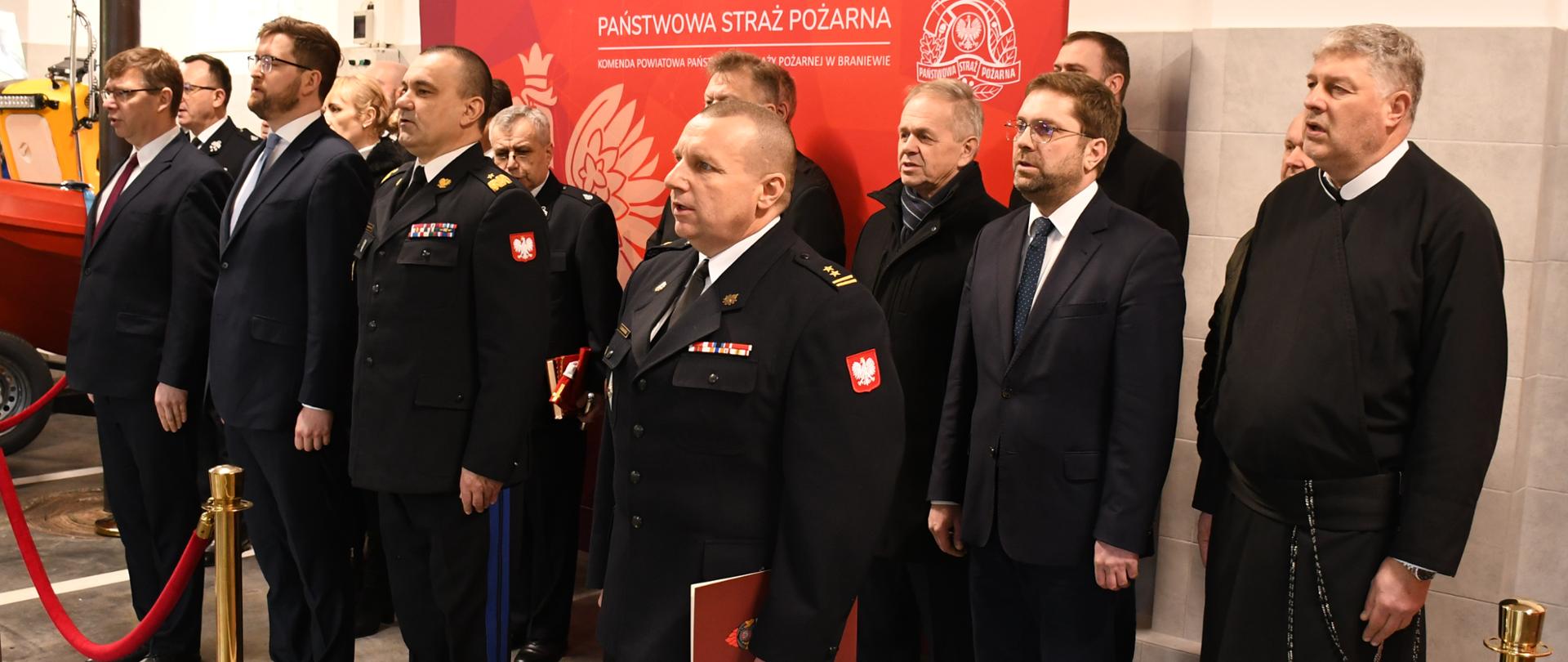 Uroczyste przekazanie samochodów pożarniczych i łodzi ratowniczej Komendzie Powiatowej PSP w Braniewie - odśpiewanie hymny państwowego. 